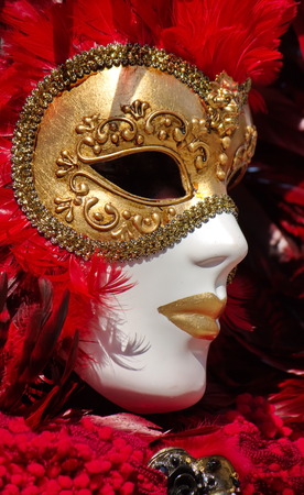 Close up on golden and red mask with feathers at the 2014 venetian carnival of Annecy, Franceの写真素材