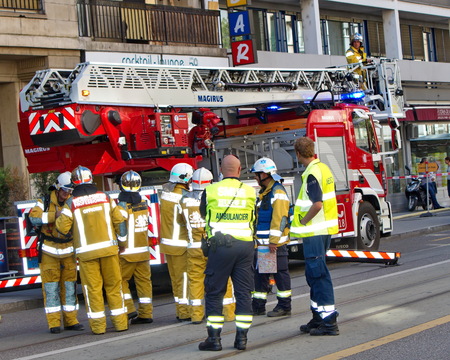 GENEVA, SWITZERLAND, AUG 22 : Firemen and medical team next to firetruck discussing intervention in Geneva, Switzerland, on August 22 2014.のeditorial素材