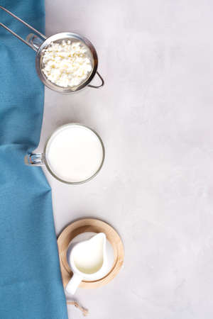 Fermented kefir drink with kefir grains. Homemade kefir, next to kefir grains, milk and a blue towel on a gray background. Vertical orientation. Bulgarian drink.の写真素材