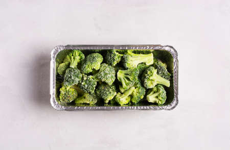 Frozen broccoli cabbage on gray surface, flat lay, healthy food concept. Horizontal orientation.の写真素材