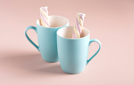 Two empty light blue mugs with marshmallows on a powdery background, horizontal orientationの写真素材