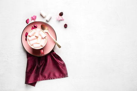 Mug with hot coffee and marshmallows on a pink plate on a gray background, horizontal orientation, flat layの写真素材