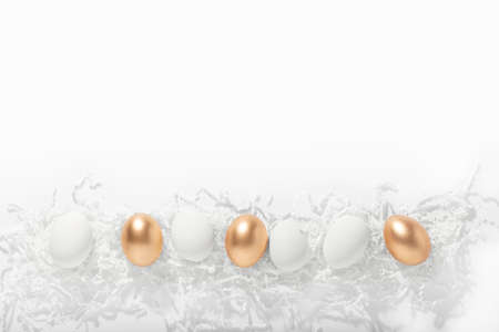Easter white and gold eggs lie on a white background, horizontal orientation, copy spaceの写真素材