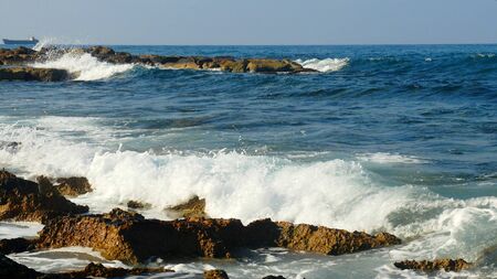 rocky shore of the blue sea, waves, white foamの写真素材