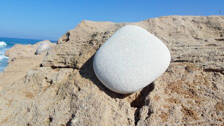 white stone on a rocky shore, blue sky, copy spaceの写真素材