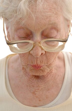 Sharp Mature woman in her eighties looking down with her big glasses.