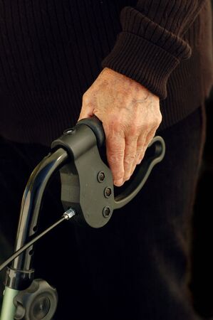Elderly woman's hand holding a walker.の写真素材