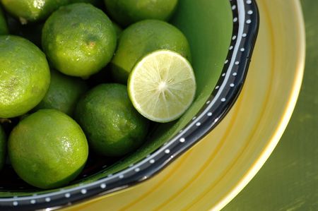 Key Limes in a bowl with one sliced.の写真素材