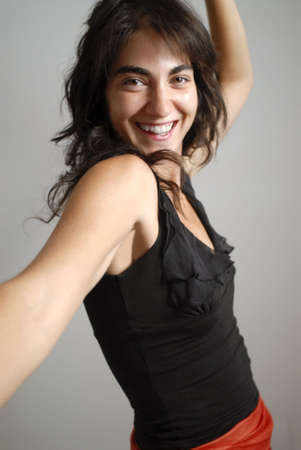 Young woman smiling as she dances. 