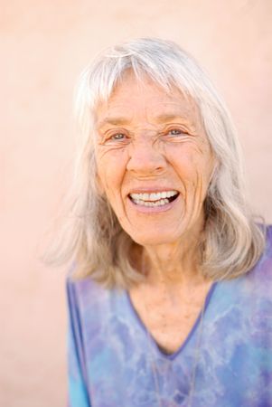 Portrait of a mature pretty woman in her late 70's laughing.