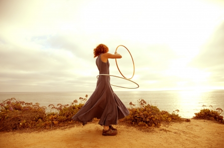 A woman hooping in the sunset. の写真素材