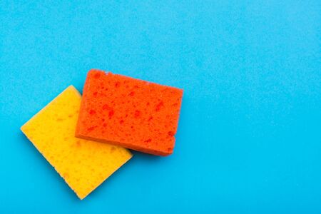 Two clean new colored sponges for washing dishes on a blue background. The concept of cleaning appliances.の写真素材