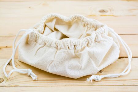 Empty opened canvas bag on the ties for food on a natural wooden background. Zero Waste Conceptの写真素材
