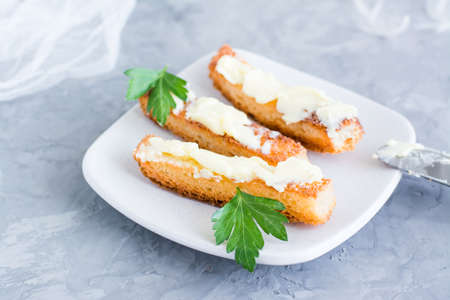 Fried toast with butter and parsley on a plate