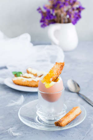 Ready-to-eat breakfast. Soft boiled chicken egg  with breadcrumbs on a standの写真素材