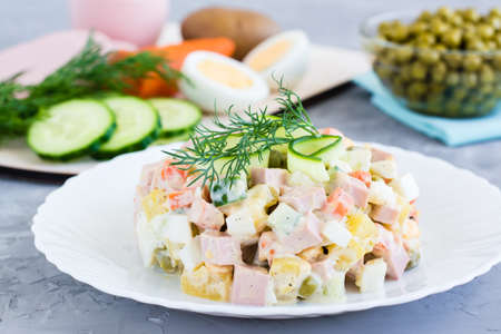 Traditional Russian salad olivier on a plate and ingredients for its preparationの写真素材