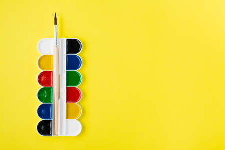 Painting tools. Watercolor and paintbrush on a yellow background. Creative leisure. Copy spaceの写真素材