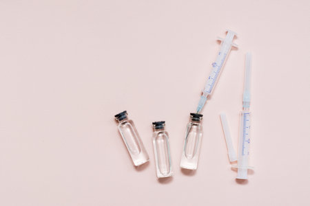 Vaccination and Immunization. Syringe needle inserted into a glass vial with vaccine. Top viewの写真素材