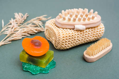 Body care. Different types of handmade soap without additives, washcloth, massager and brush on a green background.の写真素材