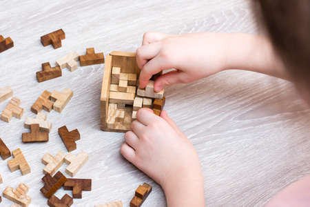Organization and order. The child folds the wooden puzzle pieces into a folding mold. Leisure for childrenの写真素材