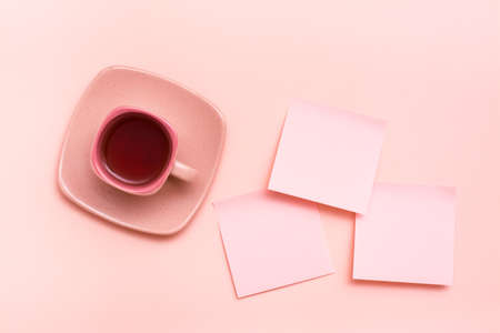The concept is pink. Pink drink in a coffee cup and sheets for writing on a pink background. Top viewの写真素材