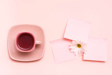 The concept is pink. Pink drink in a coffee cup, leaf for writing and chrysanthemum on a pink background. Top viewの写真素材