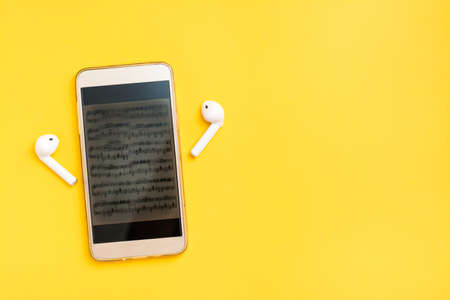 Listening to music using a smartphone and wireless headphones. Leisure with modern gadgets. Copy...