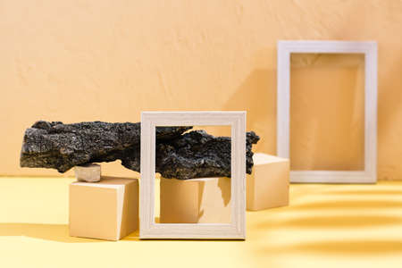 Modern abstract life style background: yellow cardboard, plaster, blank photo frames, stones, tree...