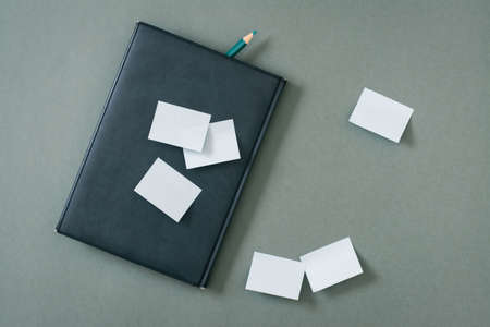 Green concept. Notepad, blank sheets for writing and a pencil on a green background. Top viewの写真素材