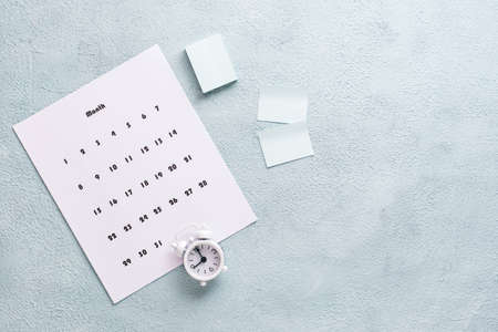 Blank sheet of monthly calendar, pages to write and alarm clock on the desktop. Time planning and organizationÑ. Copy spaceの写真素材