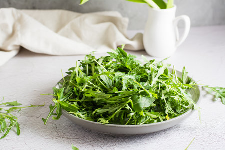 Fresh leaves of arugula on a plate on the table. Organic diet vegetarian food. lifestyleの写真素材