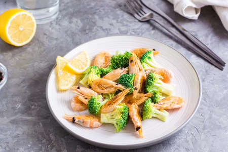 Fried broccoli and shrimp on a plate on the table. Healthy vegetarian food. close-upの写真素材