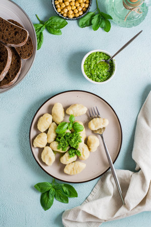 Potato gnocchi with pesto sauce on a plate on the table. Italian traditional food. Top and vertical viewの写真素材