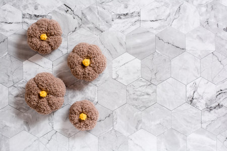 Knitted pumpkins on a marble background. Eco friendly template. top view.
