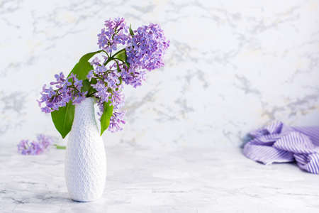 Bouquet of fresh lilacs in a white vase on the table. spring blooming still lifeの写真素材