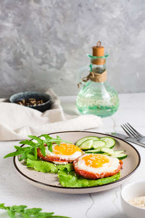 Tomatoes baked with egg and greens on a plate on the table. Homemade lunch. vertical viewの写真素材