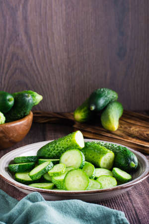 Ripe sliced cucumbers on a plate on the table. organic diet food. vertical viewの写真素材
