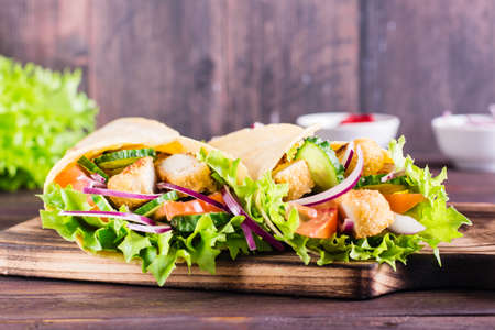 Mexican tortilla wraps with chicken and vegetables on a board on the table. close up