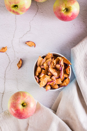 Homemade organic dried apples in a bowl and fresh fruit on the table. Top and vertical viewの写真素材