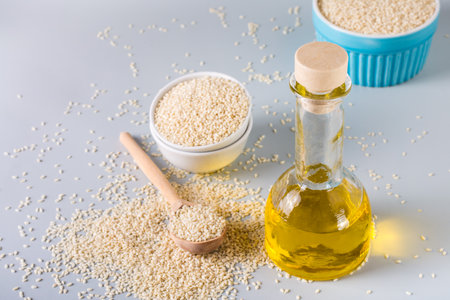 Sesame oil in a glass and seeds in a bowl on the table. Organic Alternative Foodの写真素材