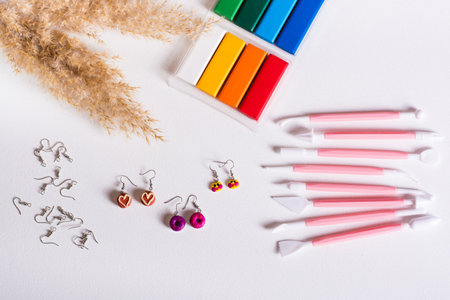 Ready-made polymer clay earrings and tools for work. Handmade and leisure. top view.