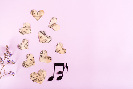 Paper hearts, notes and dry flowers on a pink background. Love music concept. top view.の写真素材