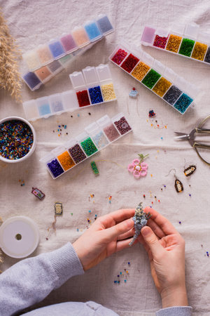 Children's hands holding a beaded parrot in the workplace. Top and vertical viewの写真素材