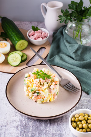 Traditional Russian Olivier salad of boiled vegetables and sausages on a plate. vertical viewの写真素材