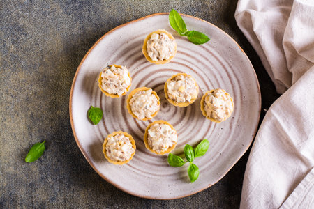 Tartlets with canned fish salad, eggs and mayonnaise on a plate. homemade snacks. top view. close upの写真素材