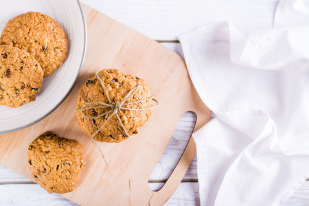 A stack of homemade oatmeal raisin cookies tied with string on a board. Healthy baking. top viewの写真素材
