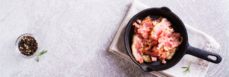 Crispy strips of bacon fried in a pan on the table. top view. web bannerの写真素材