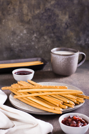 Crispy bakery straws with berry filling on a plate for dessert. vertical viewの写真素材