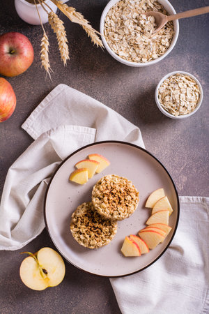 Appetizing crumble of apples and oatmeal on a plate and fruits on the table. Top and vertical viewの写真素材