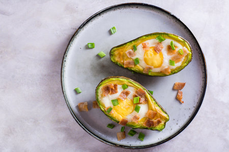Close up of baked avocado with egg, bacon and chives on a plate for a keto diet top viewの写真素材